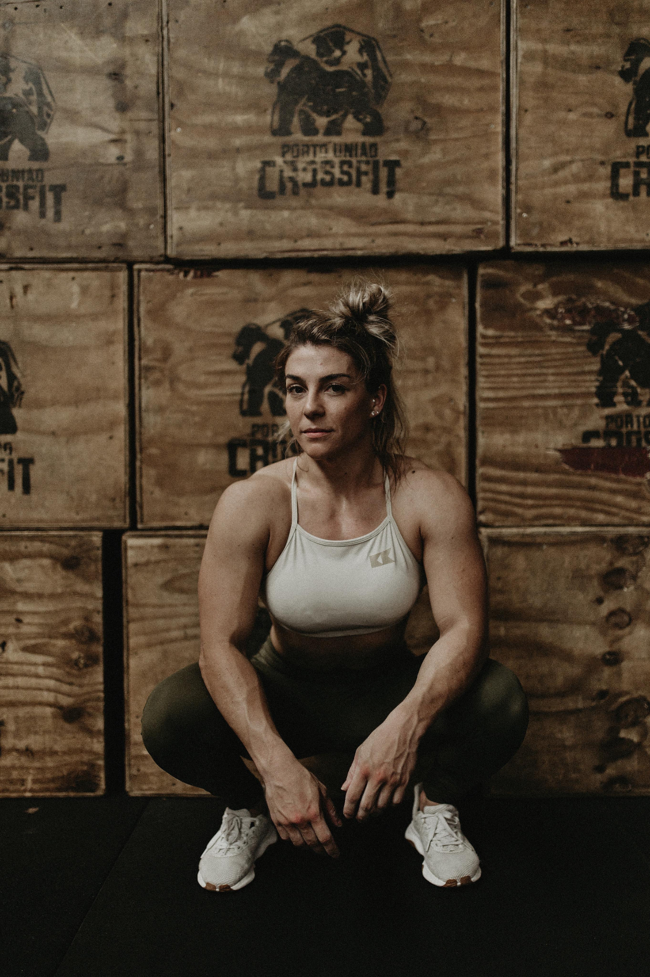 Bruna Lipinski agachada em frente às caixas do box de CrossFit