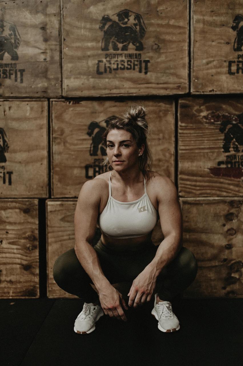 Bruna Lipinski agachada em frente às caixas do box de CrossFit